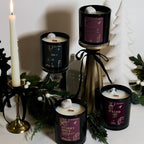 Collection of christmas candles with decorative elements on a white surface