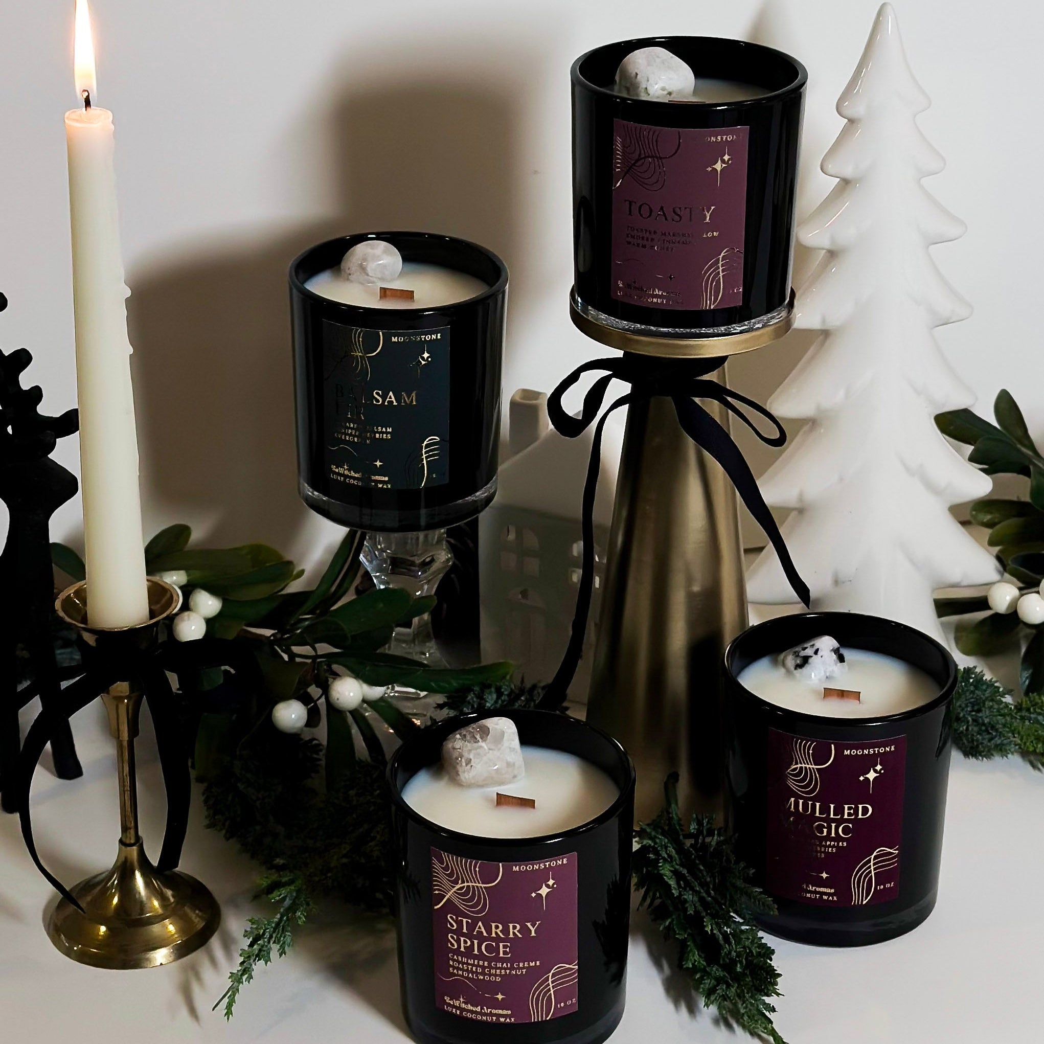 Collection of christmas candles with decorative elements on a white surface
